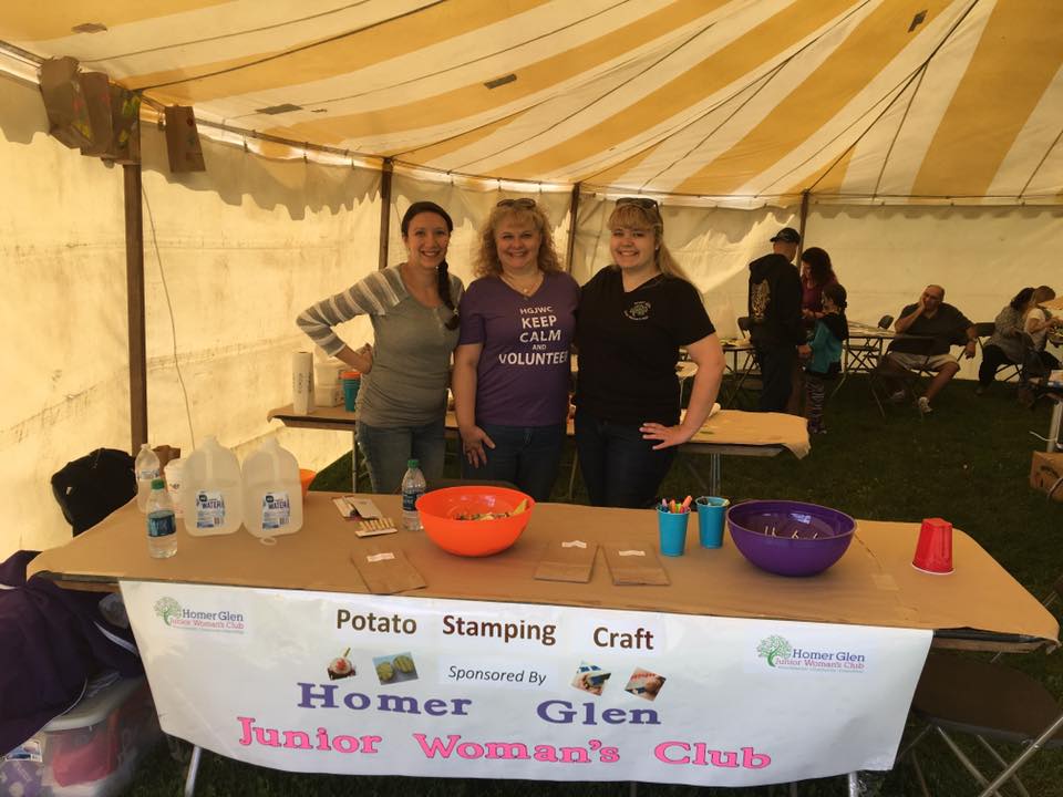 Art Committee Members volunteer at Homer Harvest Days with a kids craft